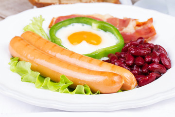 Egg fried in a green pepper, sausages, bacon and red beans
