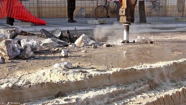 Hydraulic jack hammer is breaking concrete road