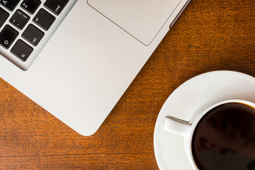 Work in the office, coffee cup with laptop  on the wooden table