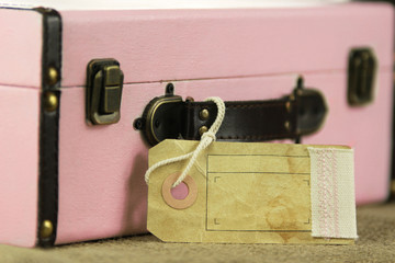 Pink retro vintage suitcase with blank paper tag