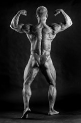 Fototapeta na wymiar The muscular male bodybuilder flexing