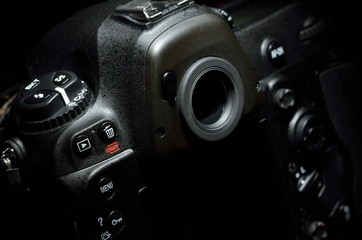 Fototapeta na wymiar professional digital photo camera against black background