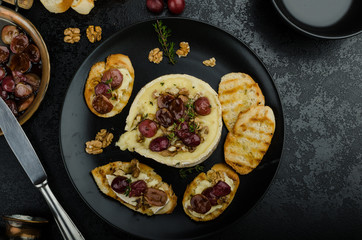 Brie cheese baked with nuts and grapes