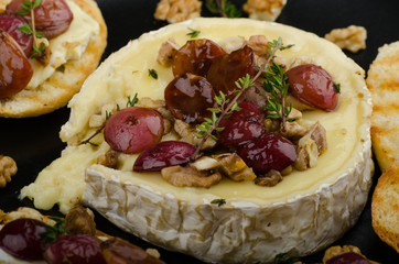 Brie cheese baked with nuts and grapes