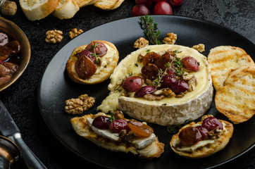 Brie cheese baked with nuts and grapes