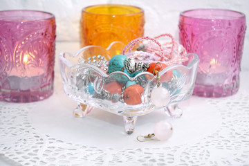 Jewelry earrings  in a glass vase with candles