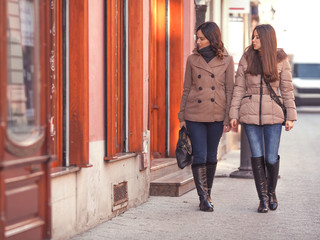 Naklejka premium Two young women in a walk looking at store window