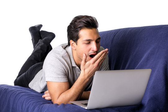 Bored Or Tired Young Man Yawning Working On Laptop Computer