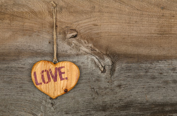 Love Valentines message wooden heart sign on rough grey backgrou