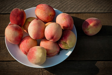 Fototapeta na wymiar bowl with some peaches on old wooden table