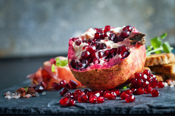 Sliced prosciutto with herbs and pomegranate seeds