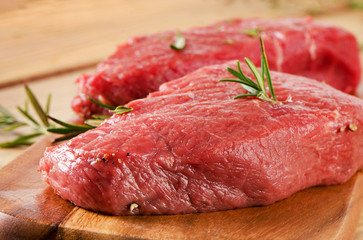 Raw  steak on   cutting board.