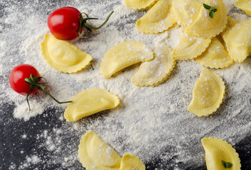 Italian raw  ravioli on a  black table.