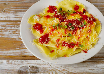 Italian  ravioli pasta with a tomato sauce on wooden table.
