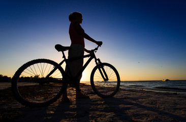 Fototapeta na wymiar woman biking at sunset