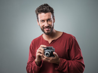 Fototapeta premium Young man taking pictures with a vintage camera