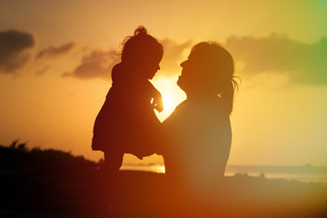 mother and daughter having fun at sunset beach