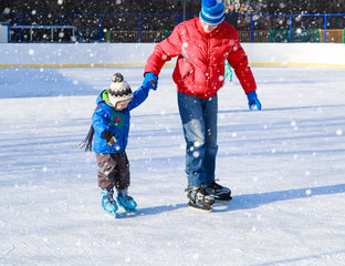 father and little son learning to skate