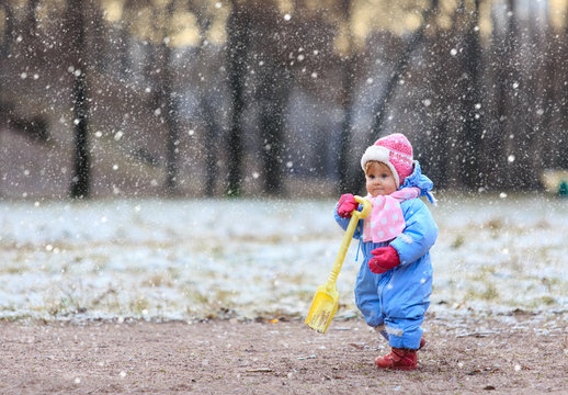 little girl making first steps in winter park