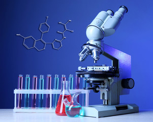 Microscope and test tubes on table, on blue background