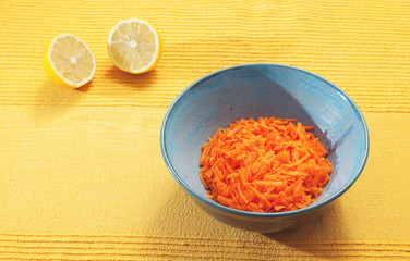 Healthy vegetarian tipical lunch. Blue bowl containing grated carrot