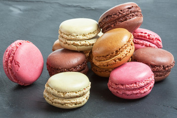 Macarons de couleurs différentes sur fond d'ardoise 