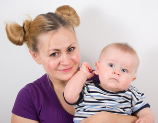 Happy mother with her little son on a gray background