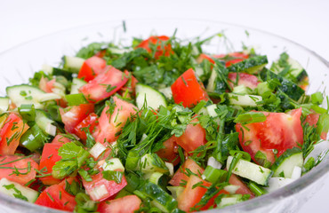 Vegetable salad with tomatoes and ccucmbers in a glass bowl