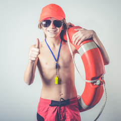 Young cute lifeguard with equipment Summertime concept Summer season safety at seaside