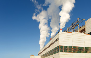 Day view of power plant, smoke from the chimney