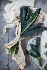 bunch of fresh lacinato kale on table with cloth
