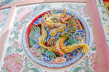 Chinese style dragon statue on a temple wall in Thailand