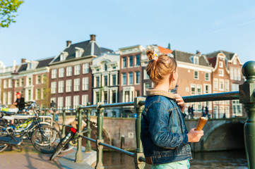 Fototapeta na wymiar Cute little girl looking on a beautiful canal in Amsterdam
