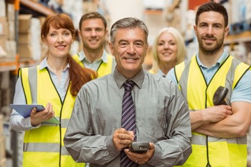 Smiling warehouse team with arms crossed