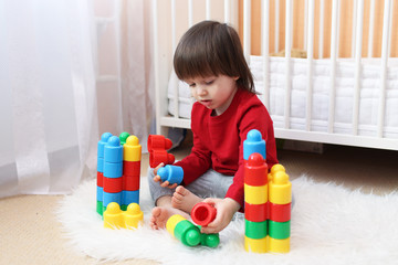 Lovely 2 years toddler playing plastic blocks