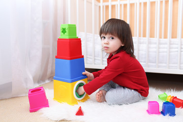 Lovely 2 years toddler playing with educational toy at home