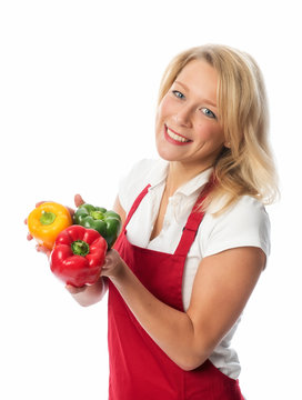 Hausfrau mit Schürze hält frische Paprika
