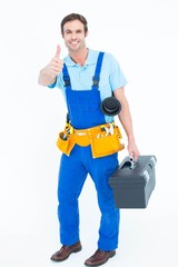 Plumber carrying tool box while gesturing thumbs up