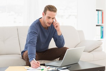 Serious man paying his bills on laptop