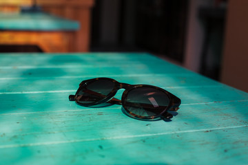 Fototapeta na wymiar Sunglasses on a table in the sunlight