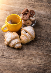 tea and croissant on wooden table