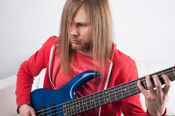 young guitarist playing guitar at home