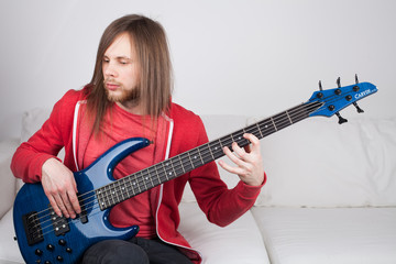 young guitarist playing guitar at home