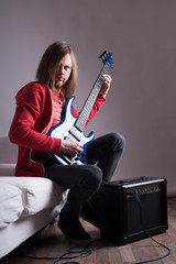 Fototapeta premium young guitarist playing guitar at home