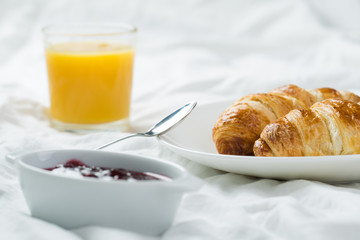 delicious breakfast with croissants in bed