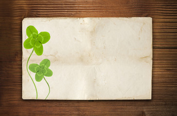clover symbol on old wood background with empty paper