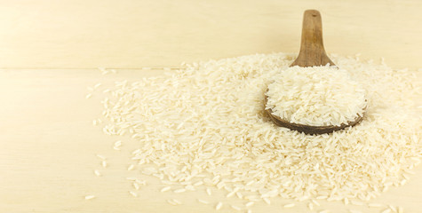 Heap of Thai jasmine rice grain on wooden