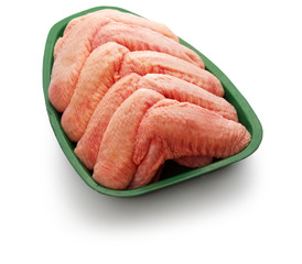 Raw chicken winglet in a green tray over white background