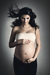 Pregnant woman over dark background