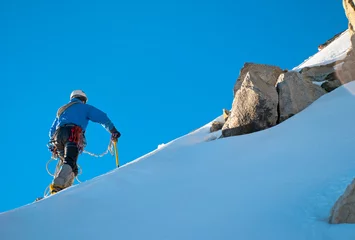 Fototapete Bergsteigen Alpine climber balances on the ice snowfield  © Andrii Vergeles